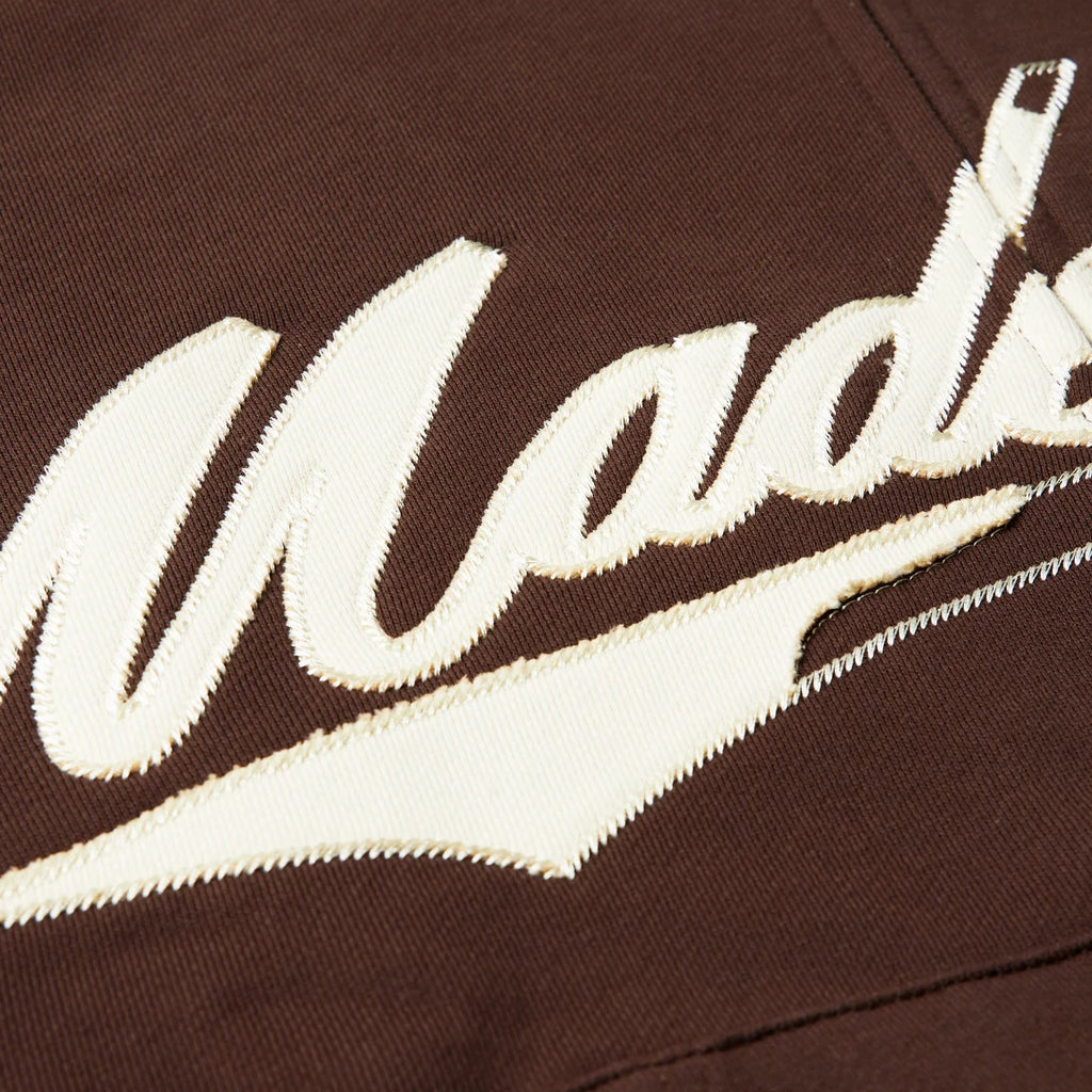 Brown sweatshirt with white embroidered text on a dark background