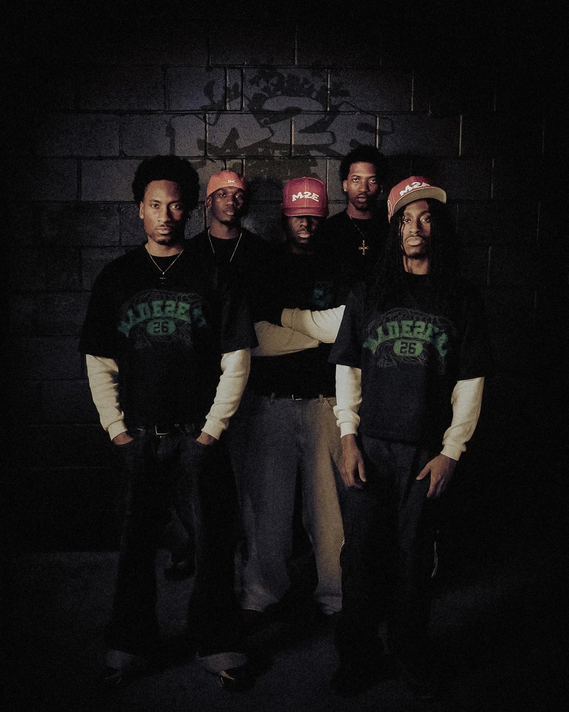 Five individuals wearing matching long-sleeve gator tees outfits in a dark setting.