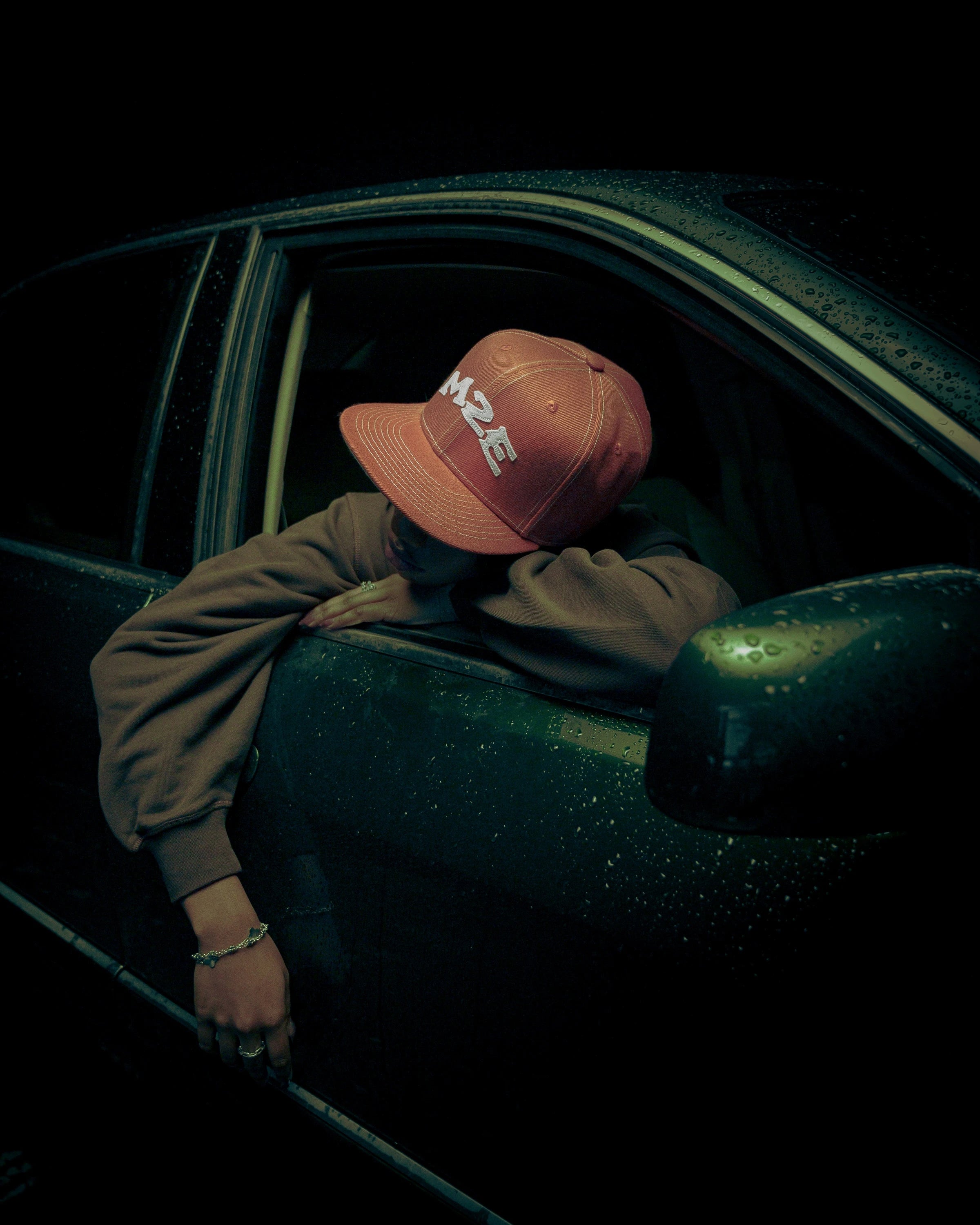 Person wearing a cap inside a car at night