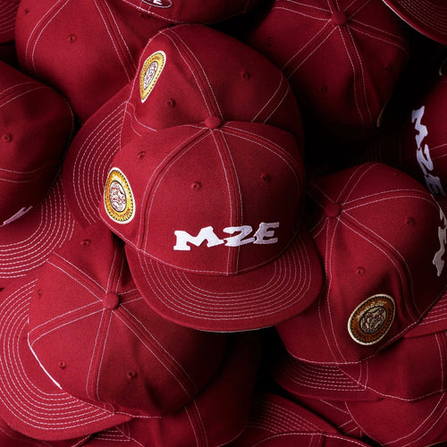 Stack of red caps with visible branding on a dark background