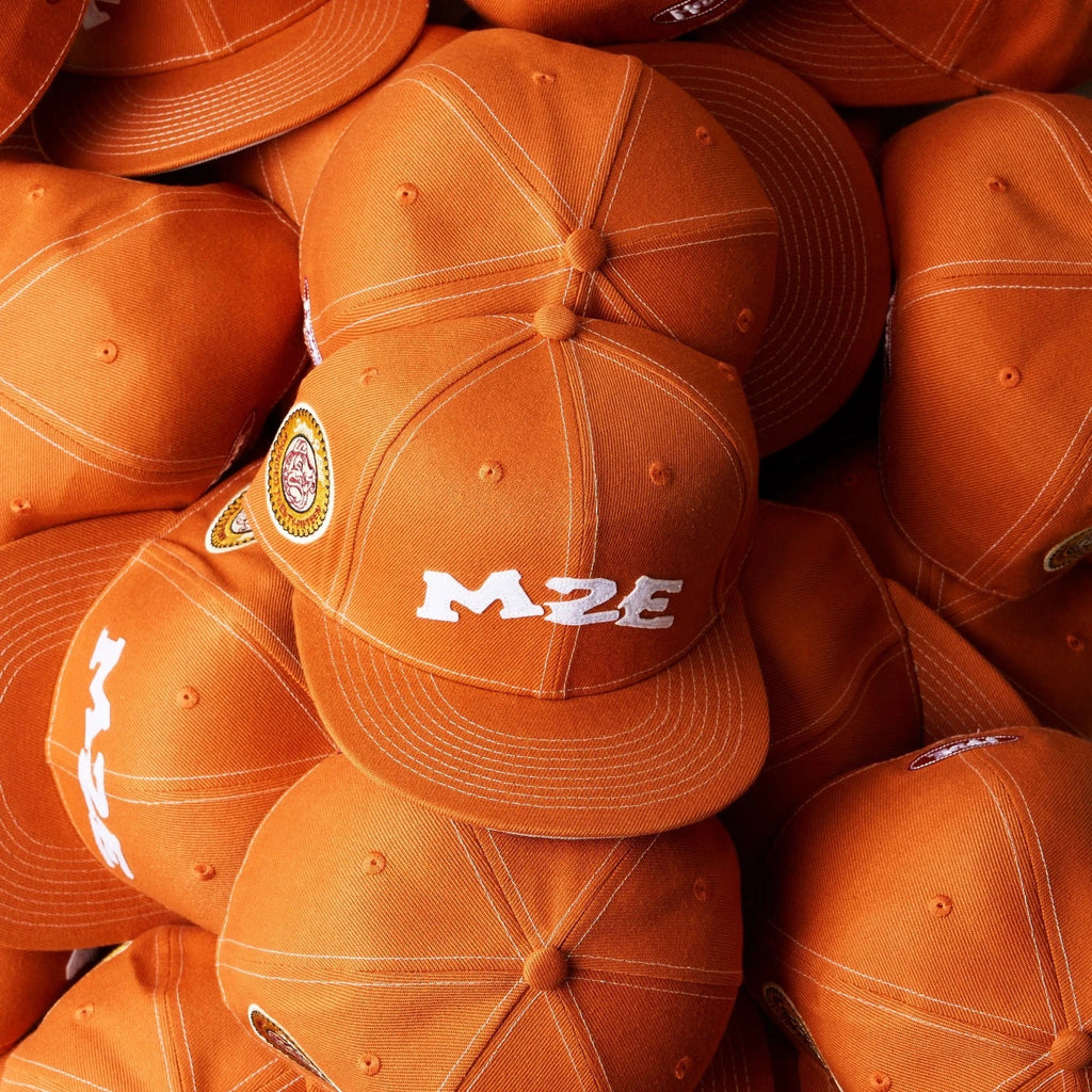 Stack of orange caps with 'M2E' branding