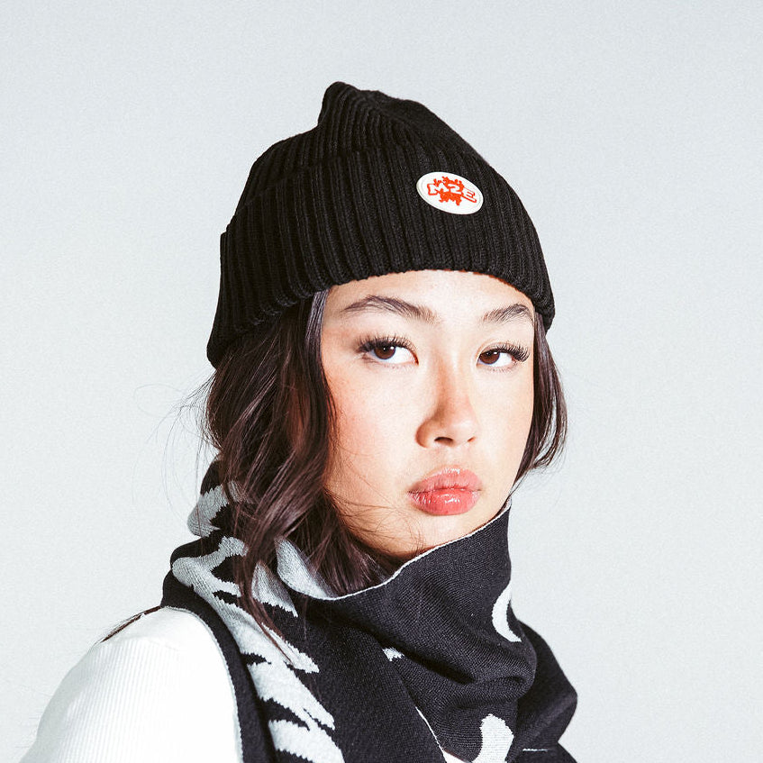 Person wearing a black M2E skully and scarf on a light gray background