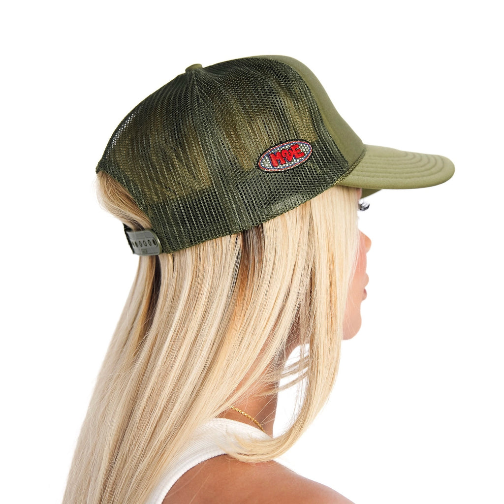 Person wearing a green M2E mesh trucker cap with a logo on a white background
