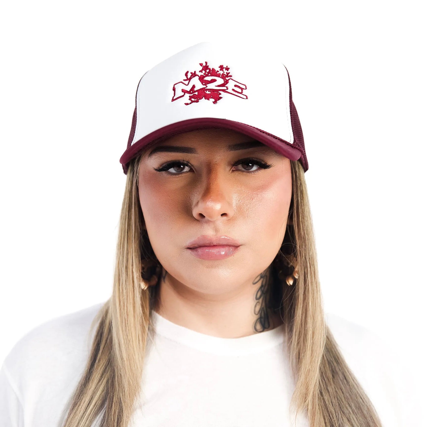 Person wearing a white and maroon M2E trucker cap with a logo on a white background